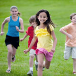 male and female children running on grass.