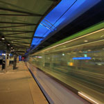 a photo of a train station platform with a blurred train going by.